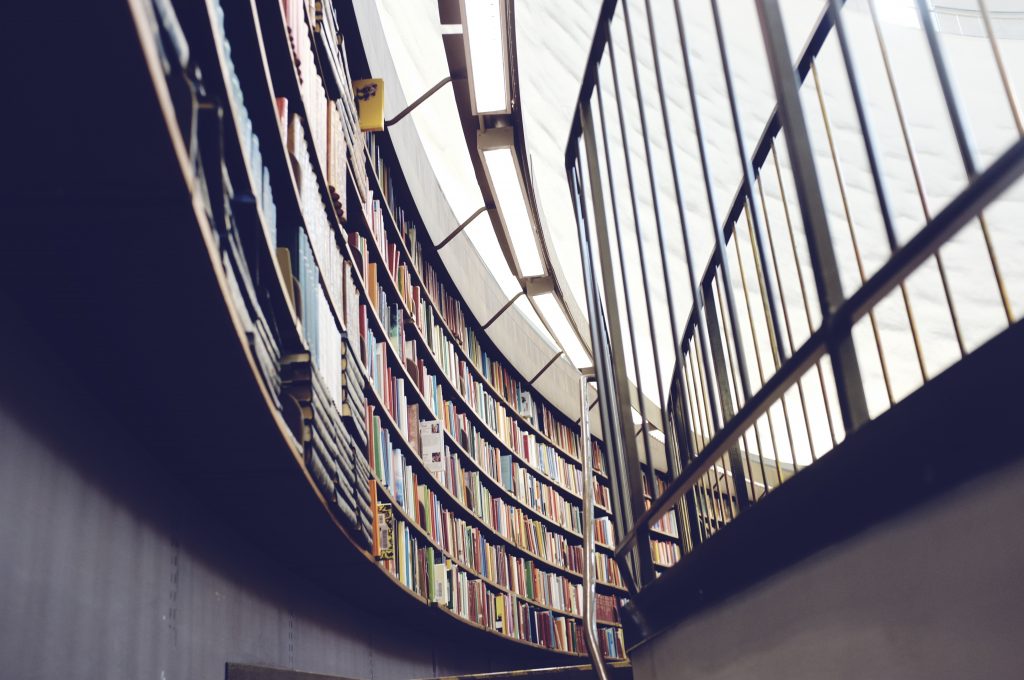 Books on shelves mounted along a curved library wall 