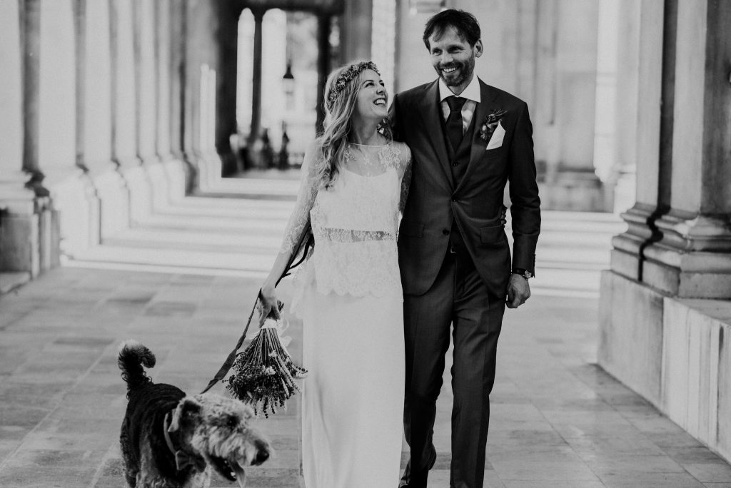 Image of a bride and groom walking with their dog taken by Fern Edwards